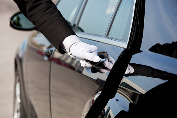 The white gloved hand of a uniformed chauffeur opening / closing a luxury car door